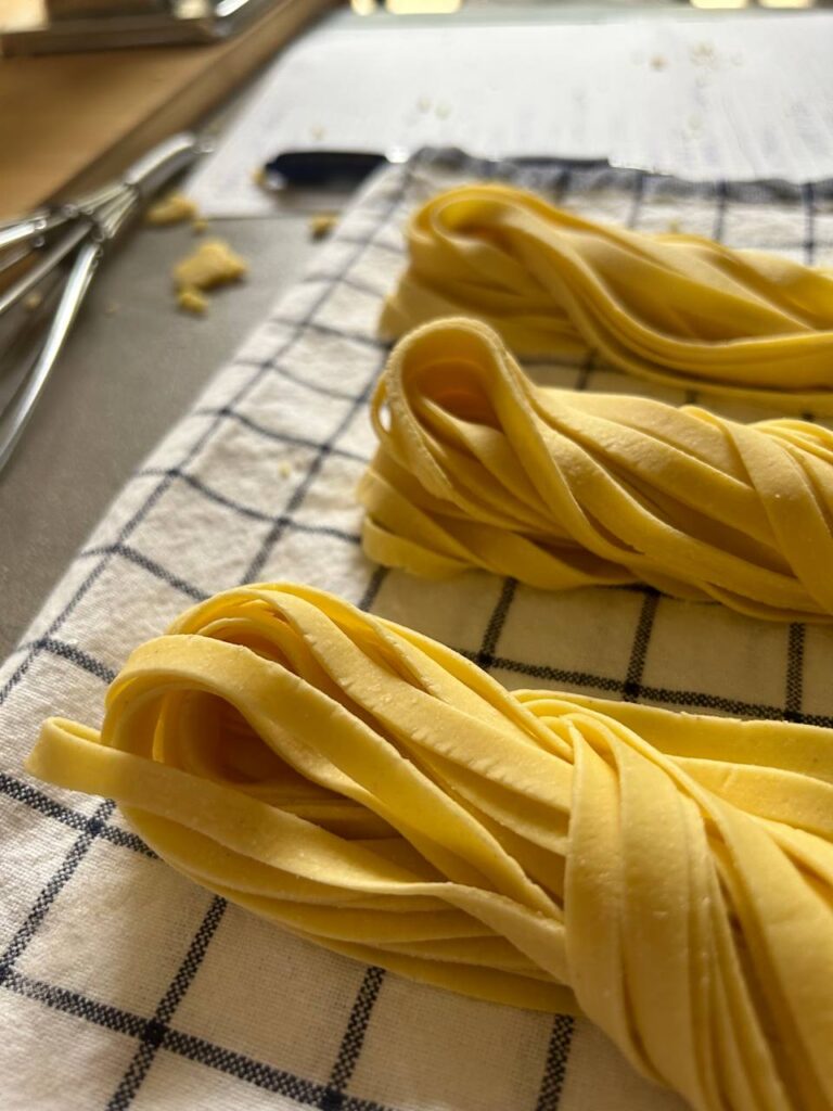 Nidi di tagliatelle fresche all'uovo su un canovaccio a quadri