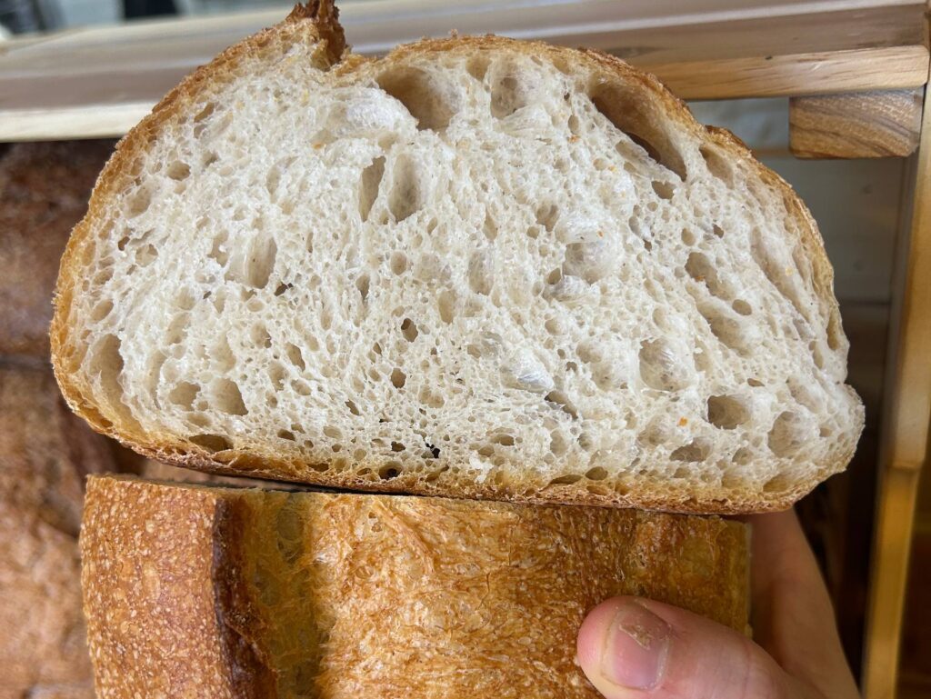 Pagnotta tagliata a metà con la mollica alveolata e la crosta dorata