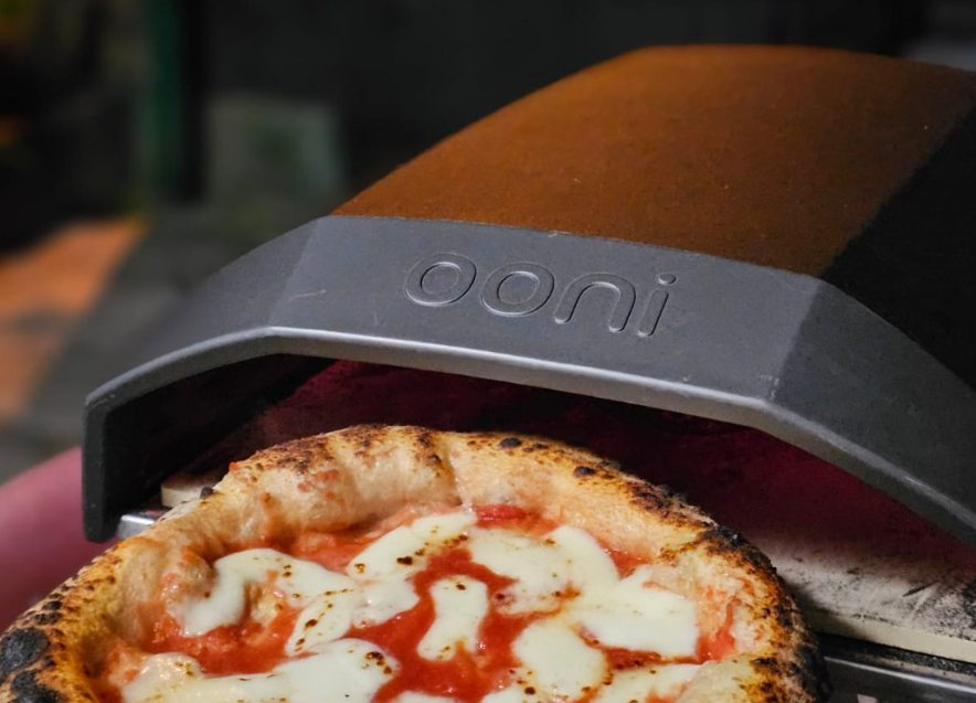 Pizza margherita che cuoce in un forno da pizza portatile